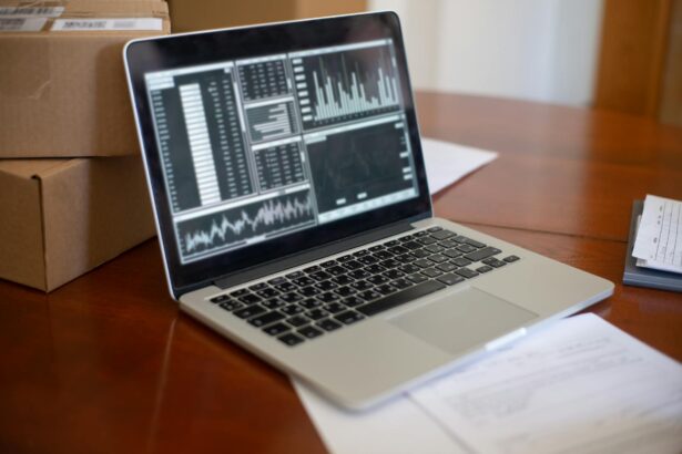 laptop displaying charts standing on the table next to cardboard boxes